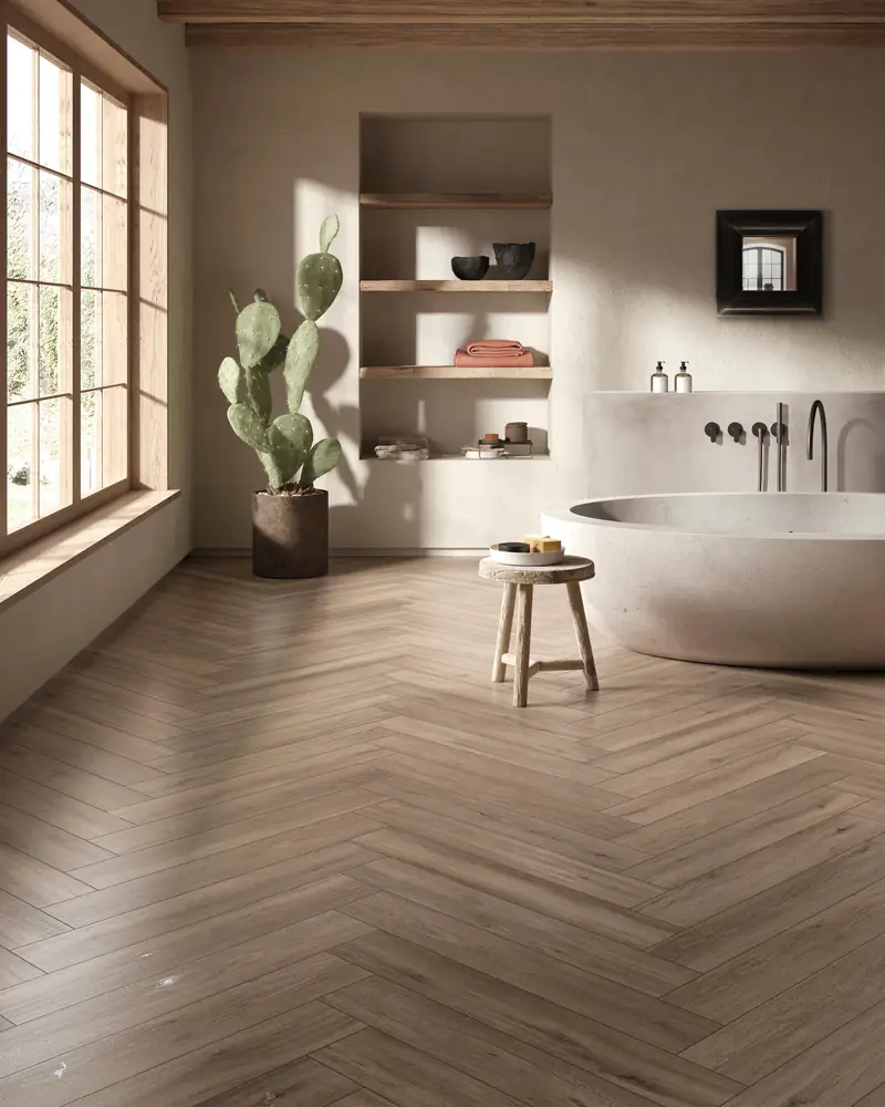 Bagno con vasca freestanding e pavimento effetto legno posato a spina di pesce